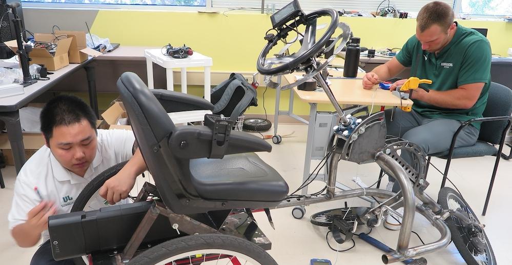 Engineering students working on adaptive trikes